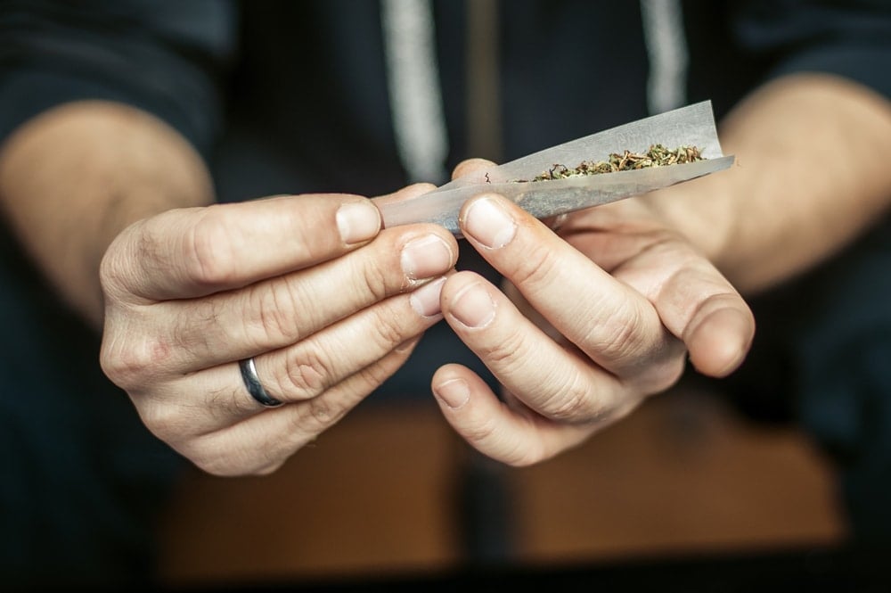 A hand rolling a joint